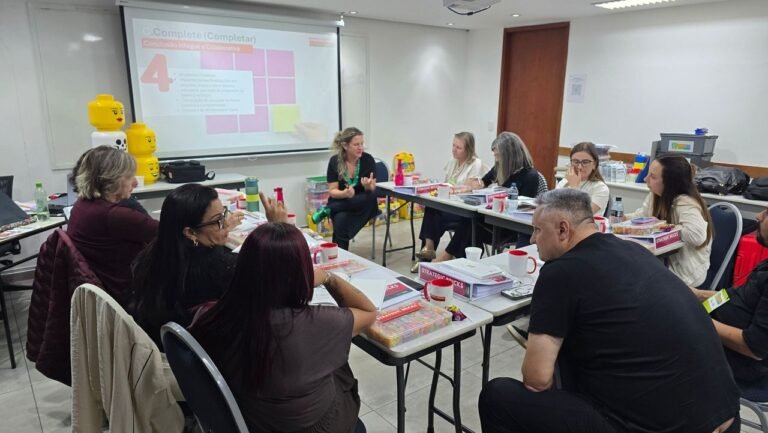 Participantes em atividade com materiais sobre as mesas