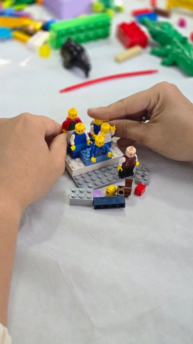 Mãos montando peças em uma atividade prática